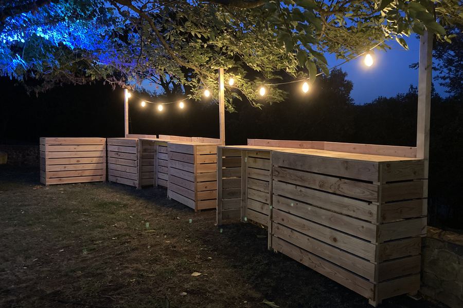 Filera de casetes de fusta il·luminades de nit amb garlandes